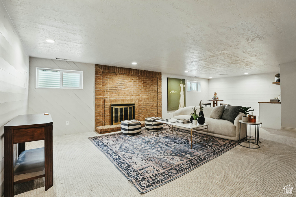 Living area featuring carpet flooring, a fireplace, healthy amount of natural light, recessed lighting, and a textured ceiling