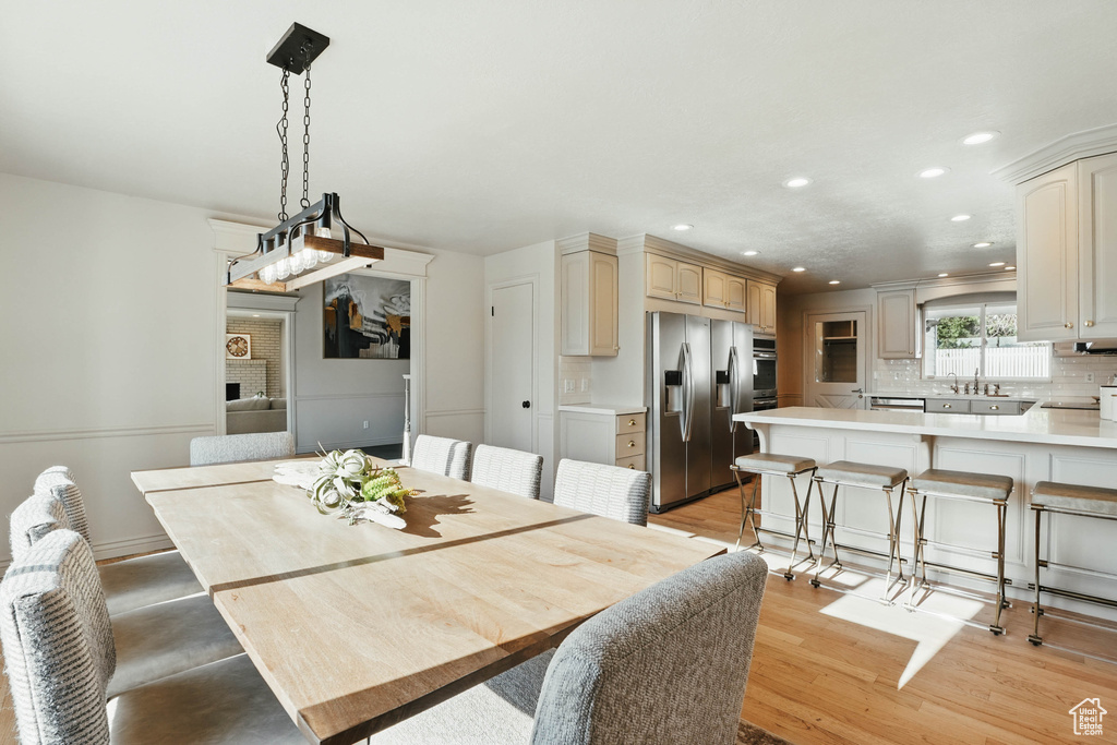 Dining area with recessed lighting and light wood finished floors