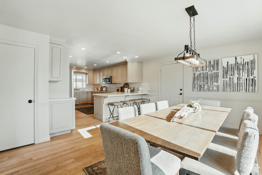 Dining room with light wood-type flooring and recessed lighting