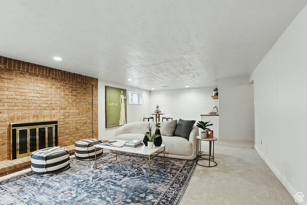 Carpeted living area with a fireplace, baseboards, and recessed lighting