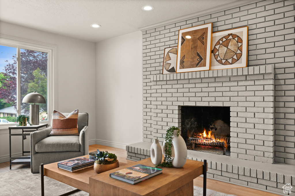 Living room with a fireplace, wood finished floors, recessed lighting, and baseboards