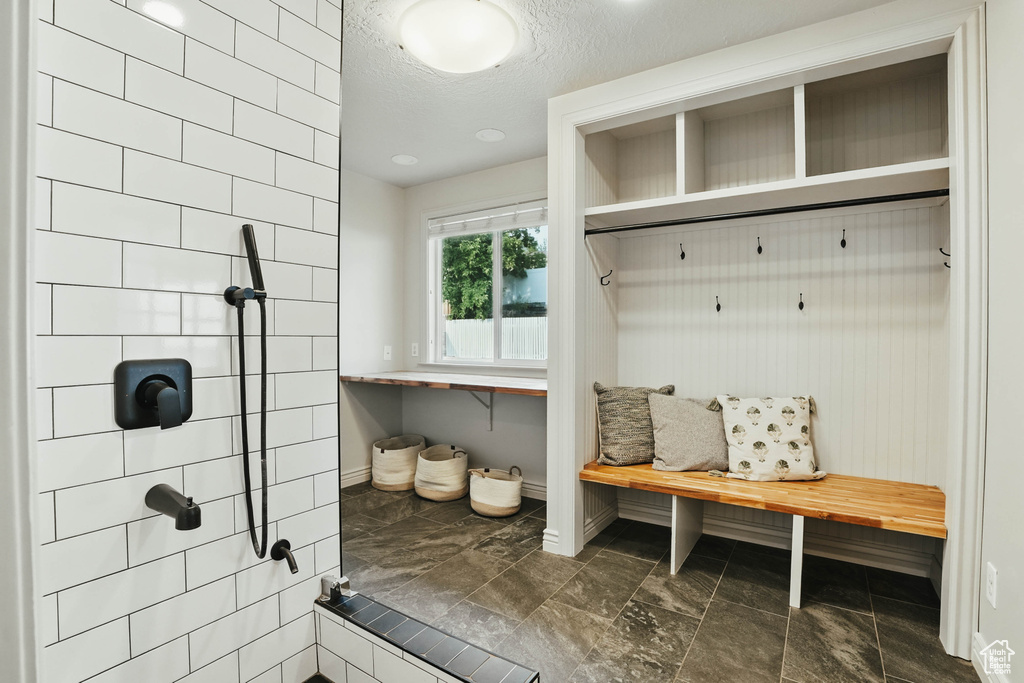 Mudroom with baseboards and a textured ceiling