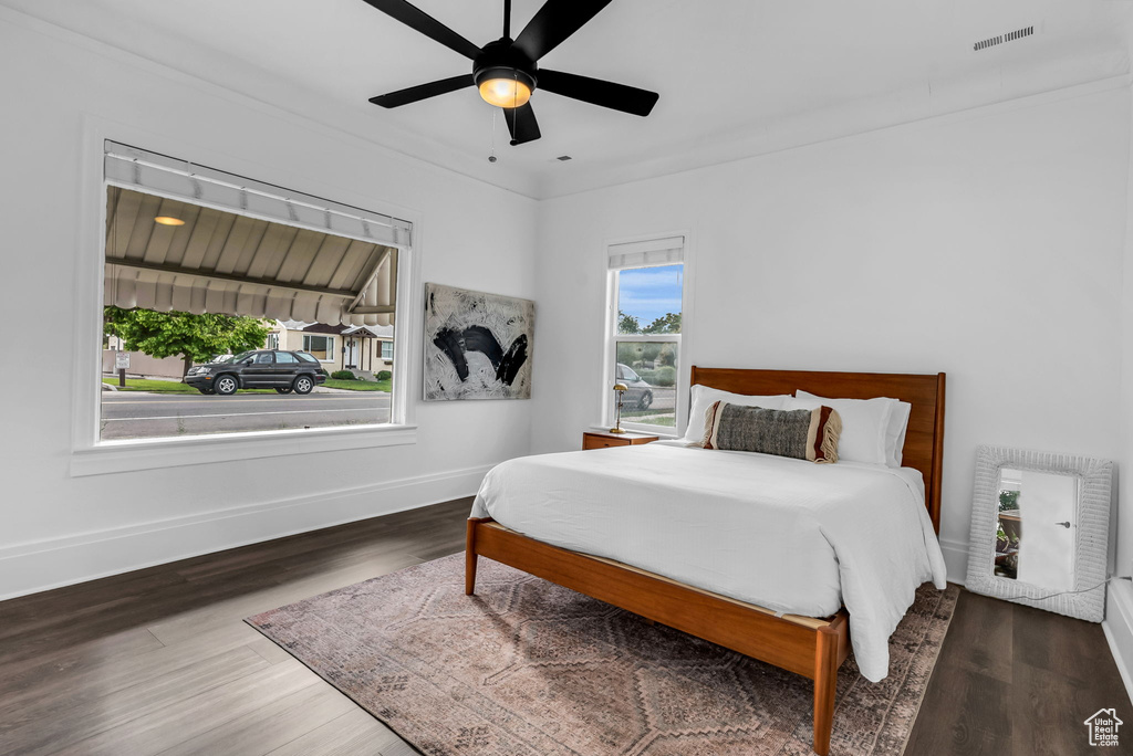 Bedroom featuring baseboards, wood finished floors, and a ceiling fan