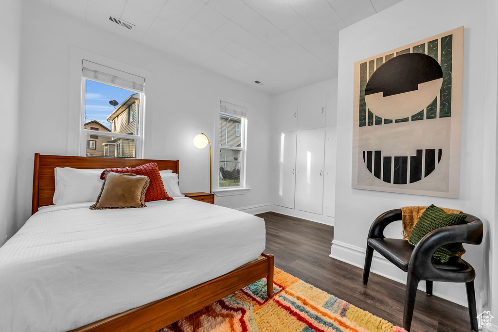 Bedroom featuring dark wood-type flooring and baseboards