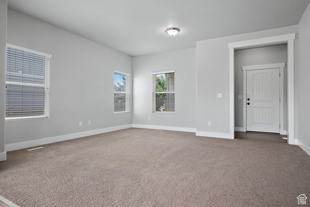 Carpeted empty room featuring baseboards
