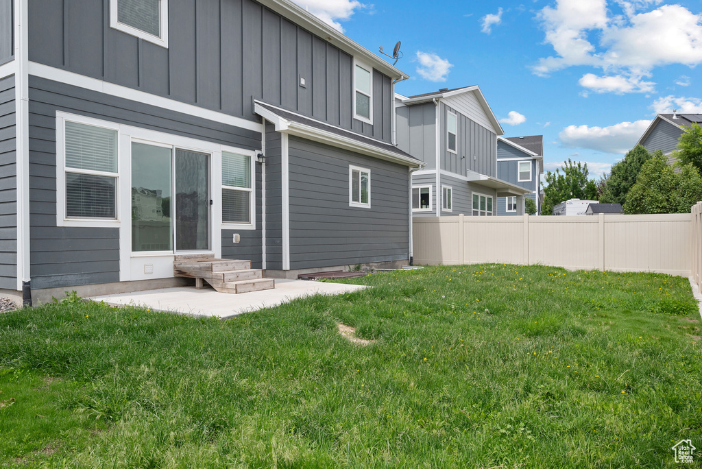 Rear view of house with board and batten siding and a patio