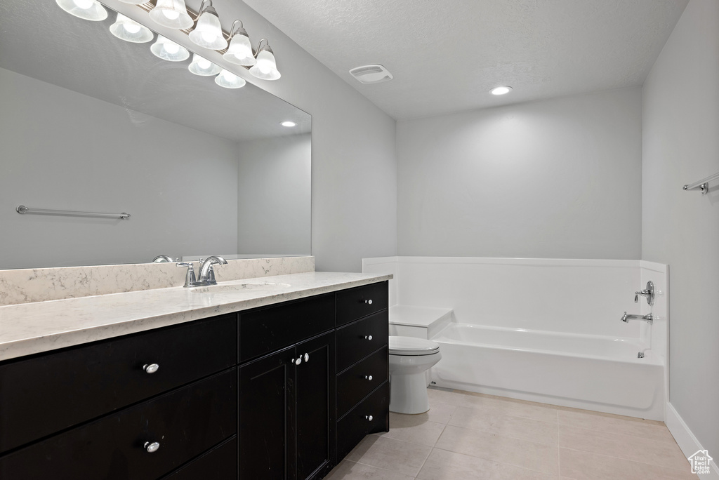 Full bath featuring vanity, a garden tub, toilet, tile patterned floors, and baseboards