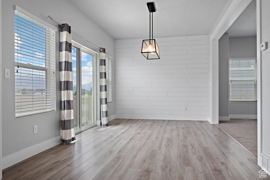 Unfurnished dining area featuring wood finished floors and baseboards