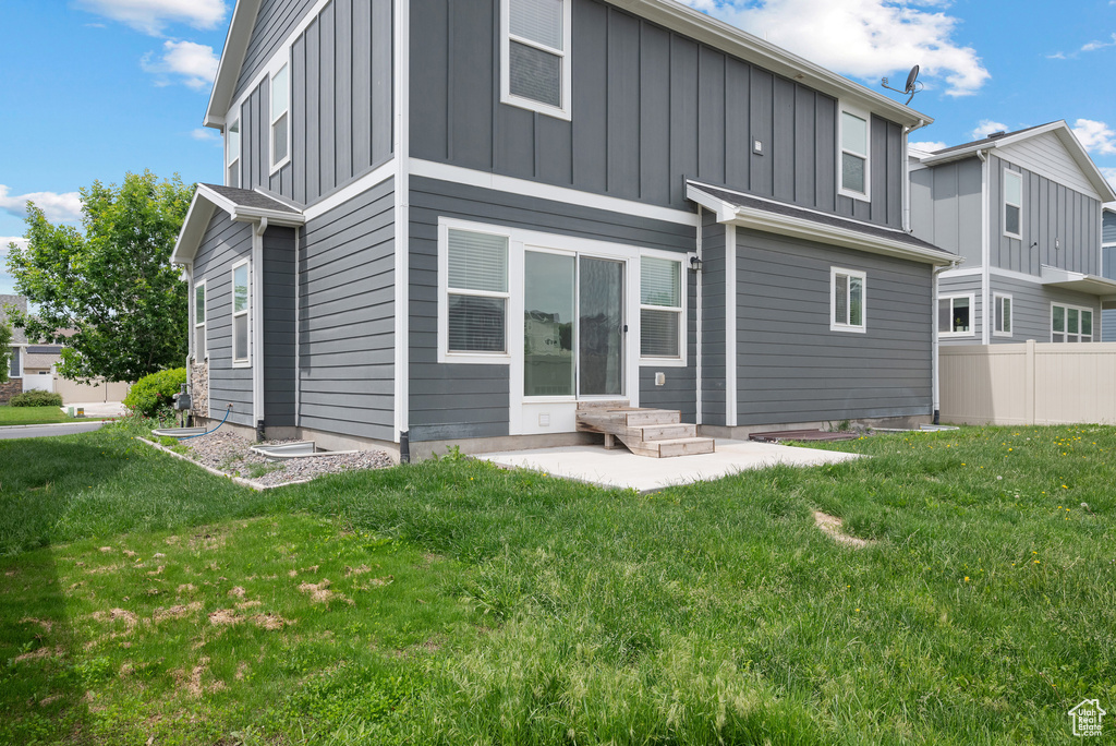 Rear view of property with board and batten siding