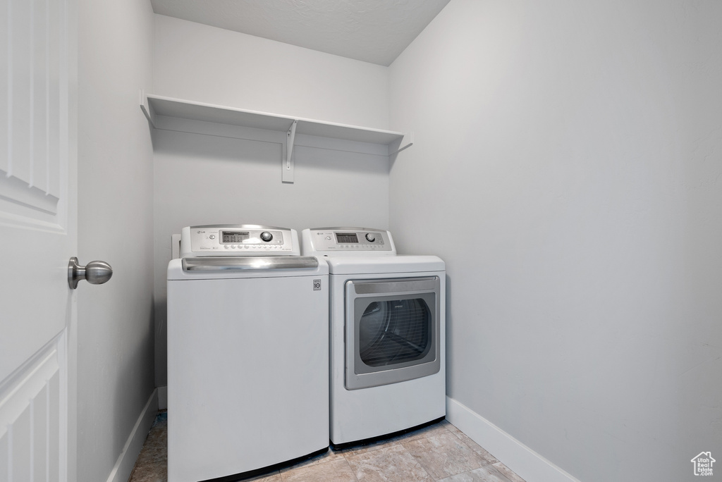 Laundry area featuring separate washer and dryer and baseboards
