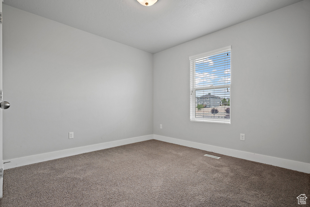 Empty room with carpet flooring and baseboards