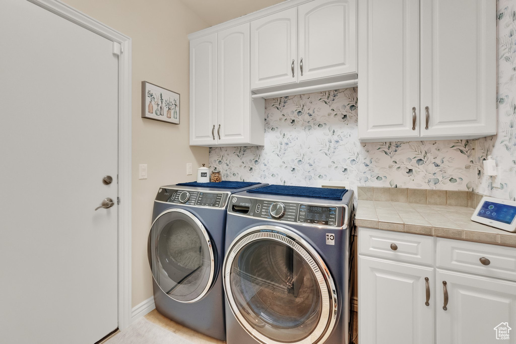 Laundry room with independent washer and dryer and cabinet space