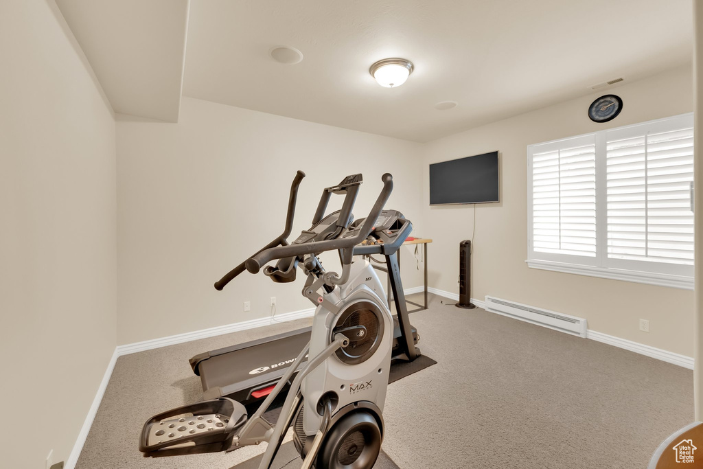 Workout room with baseboard heating, carpet, and baseboards