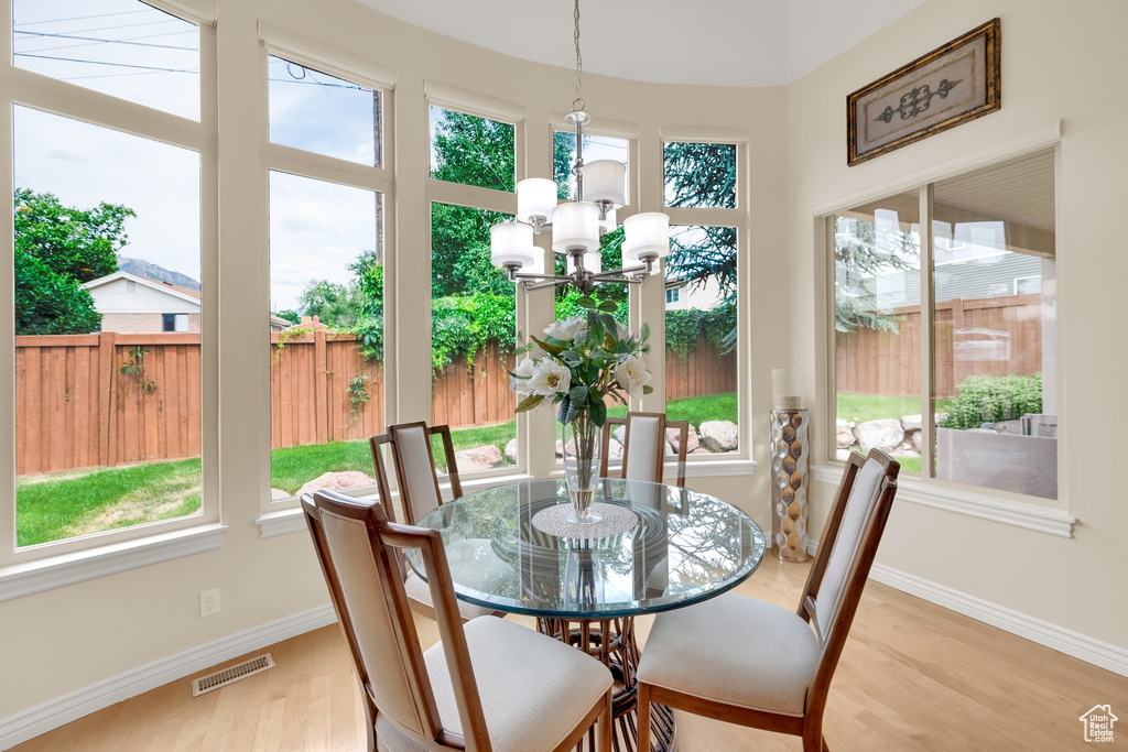 Dining room with baseboards, light wood finished floors, and a chandelier