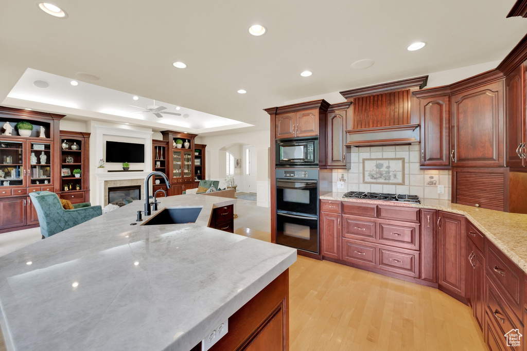Kitchen featuring a sink, black appliances, ceiling fan, light wood finished floors, and recessed lighting