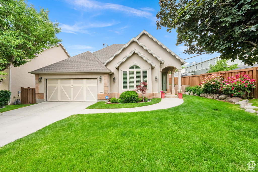 View of front of property featuring stucco siding, a garage, concrete driveway, and roof with shingles