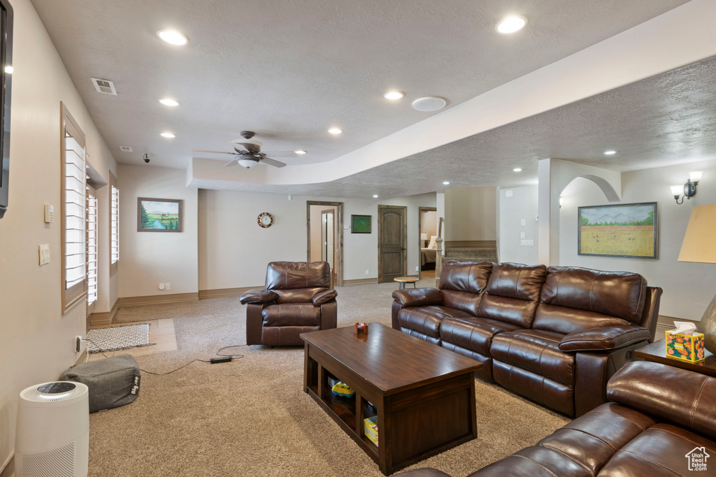 Carpeted living area with recessed lighting, baseboards, ceiling fan, and a textured ceiling