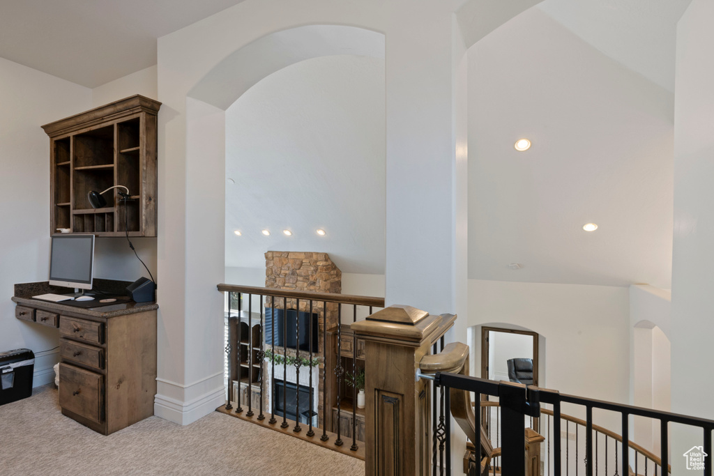 Home office with carpet floors and arched walkways