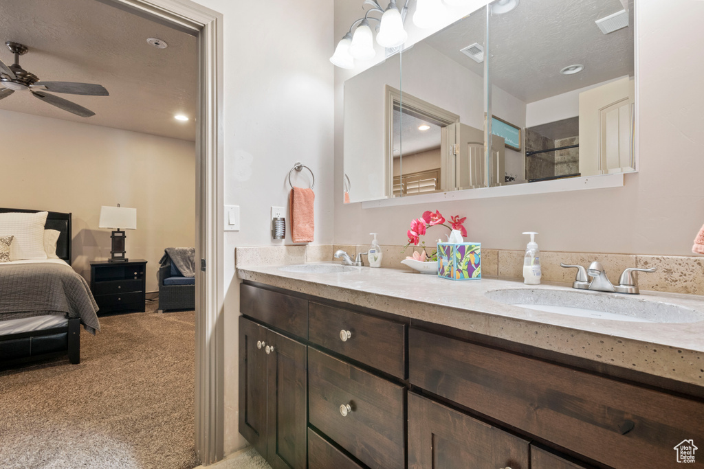 Bathroom featuring ensuite bathroom, double vanity, a ceiling fan, and recessed lighting