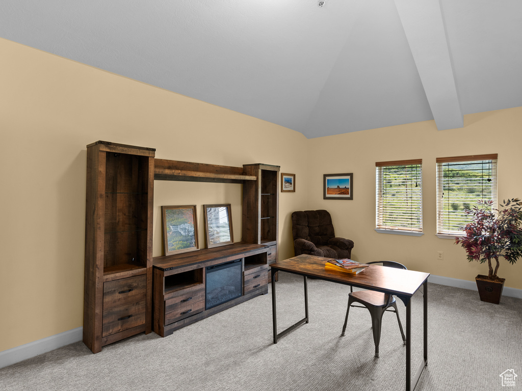 Office space featuring carpet, baseboards, and lofted ceiling