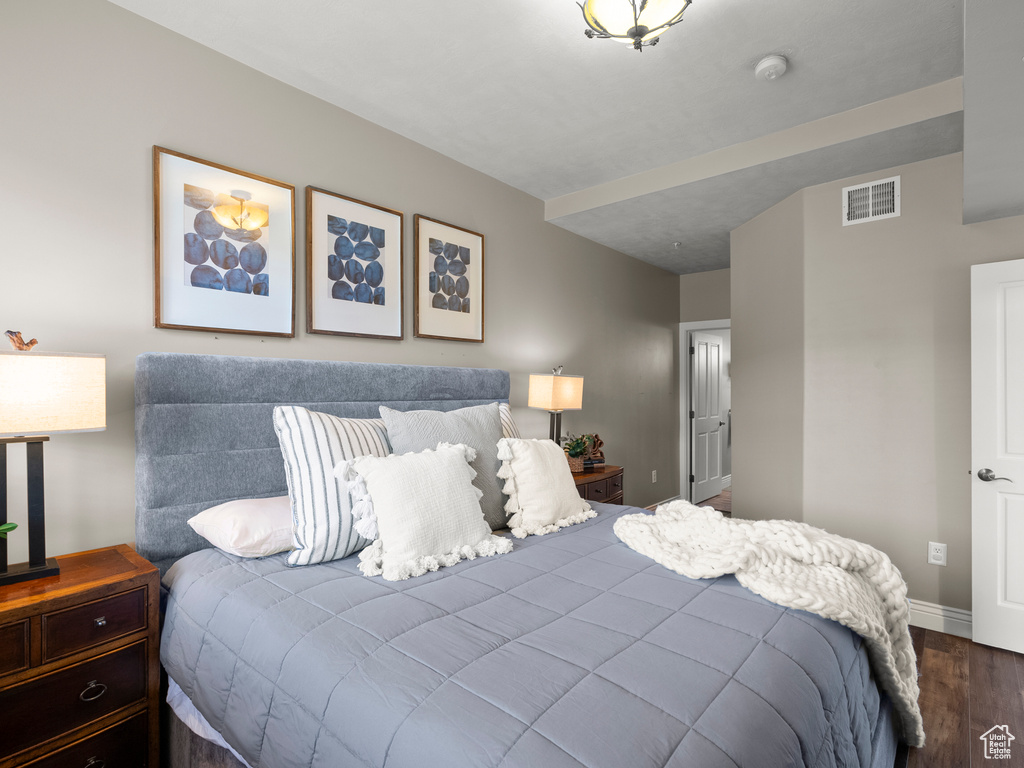 Bedroom featuring dark wood-style flooring and baseboards
