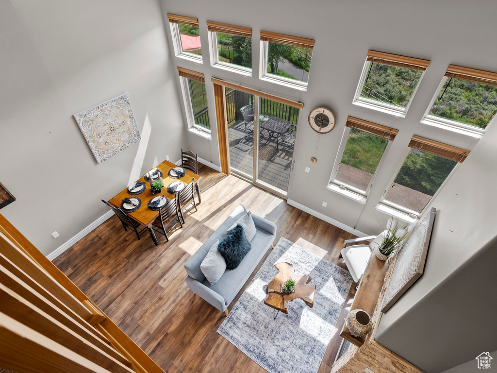 Living room with baseboards, wood finished floors, and a high ceiling