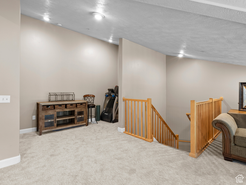 Interior space featuring an upstairs landing, carpet floors, and baseboards