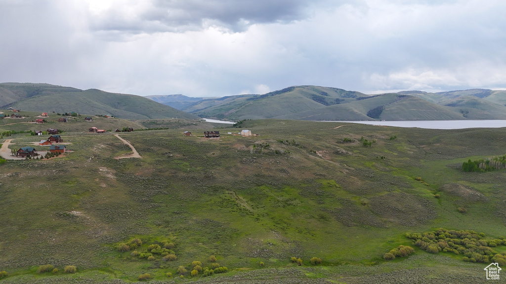 View of mountain backdrop with a nearby body of water and rural landscape