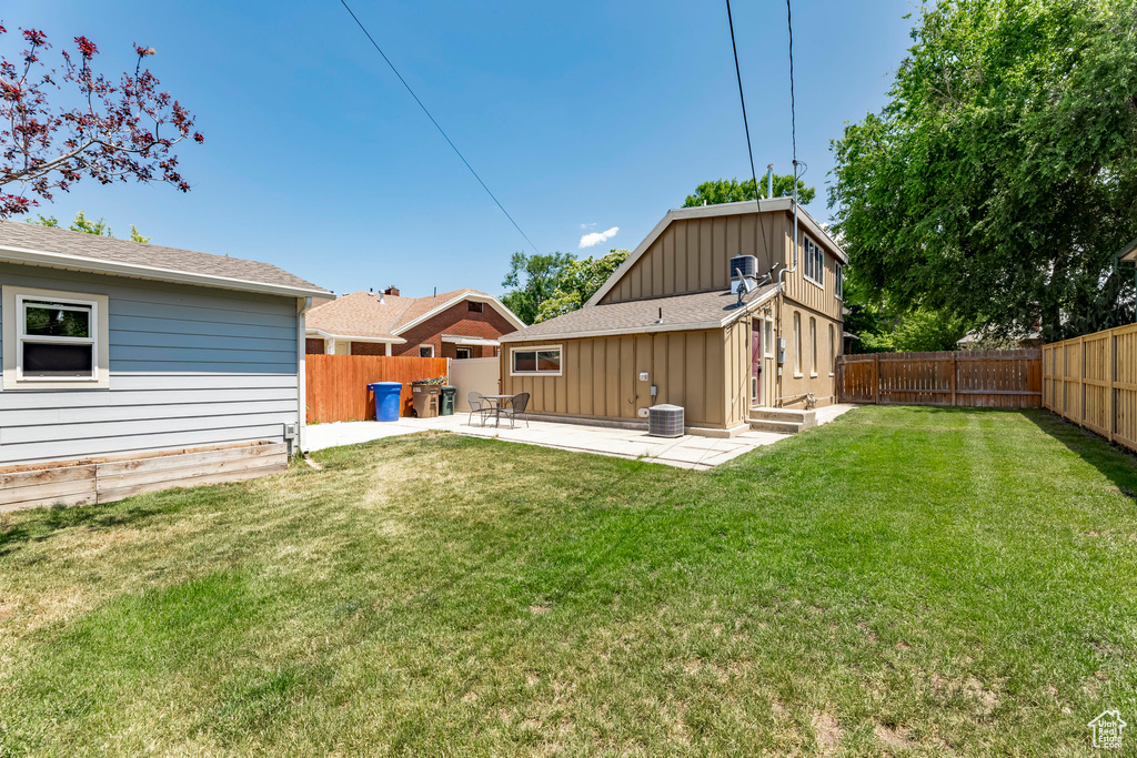 Back of house featuring a patio, central AC, and roof with shingles
