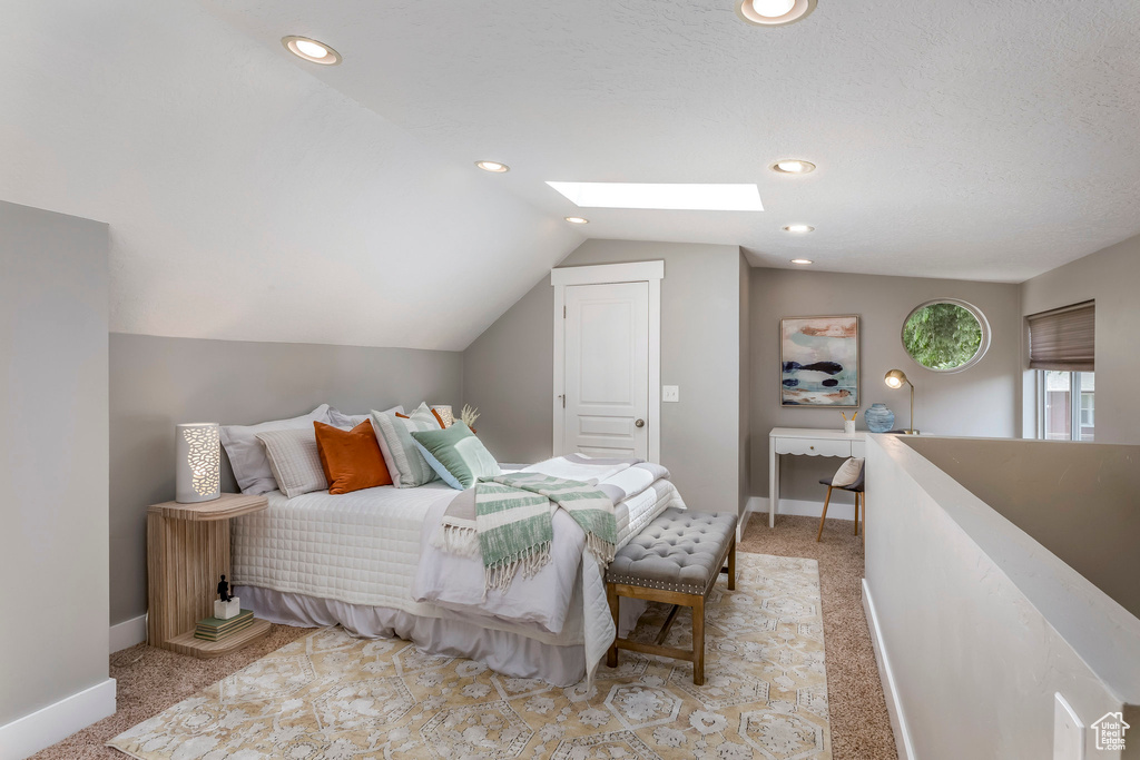 Bedroom featuring light carpet, vaulted ceiling, a skylight, baseboards, and recessed lighting