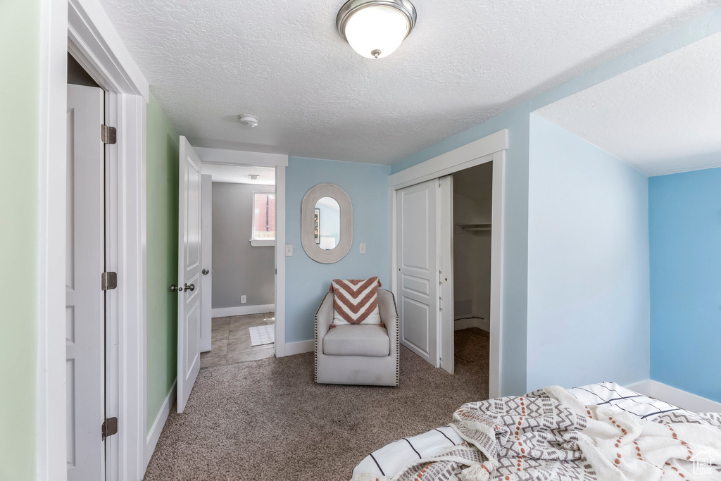 Bedroom with carpet flooring, a closet, a textured ceiling, and baseboards