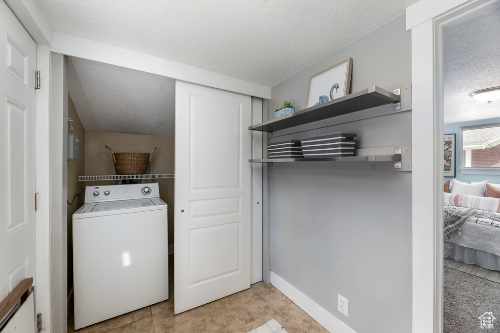Washroom featuring washer / clothes dryer and a textured ceiling