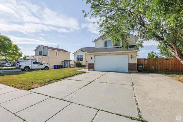 Traditional-style house featuring driveway, brick siding, and an attached garage