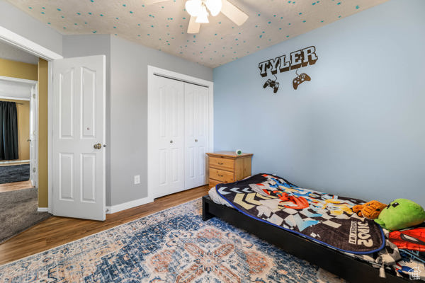 Bedroom featuring wood finished floors, a closet, a ceiling fan, and baseboards