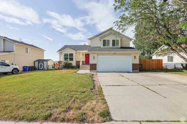 View of front of house with driveway, brick siding, and an attached garage