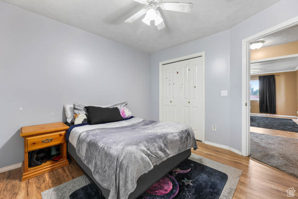 Bedroom featuring baseboards, wood finished floors, and a closet