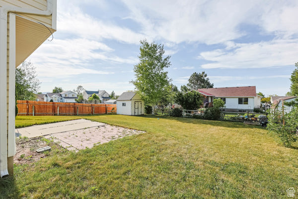 View of yard featuring an outdoor structure, a residential view, and a patio area