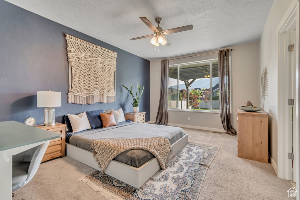 Bedroom featuring carpet flooring, a textured ceiling, baseboards, and ceiling fan