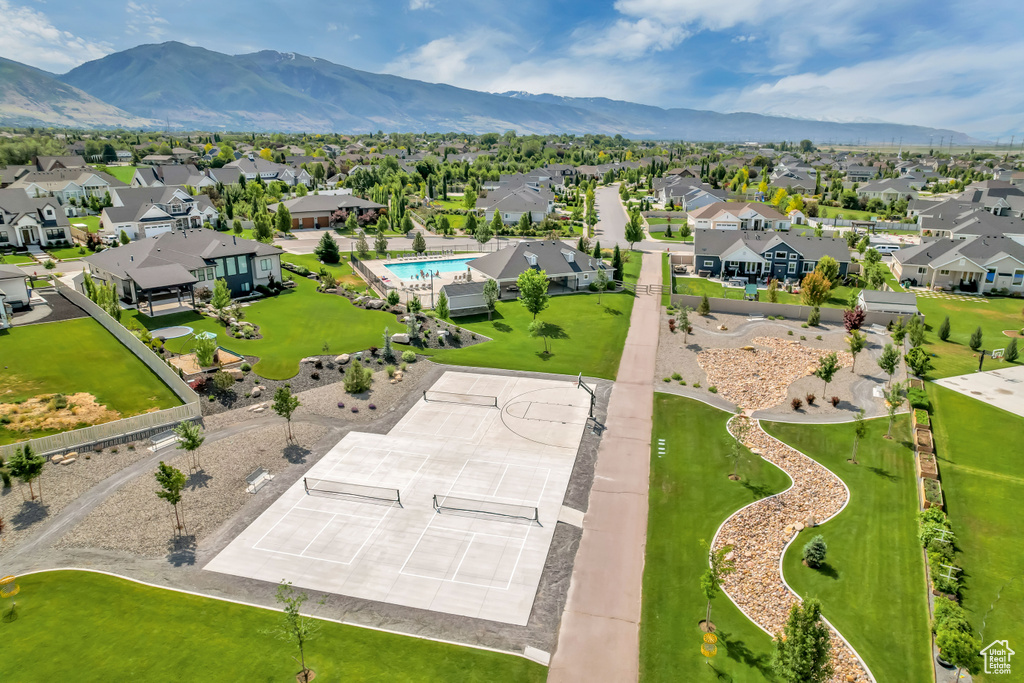 Aerial view of residential area featuring a mountainous background and a pool