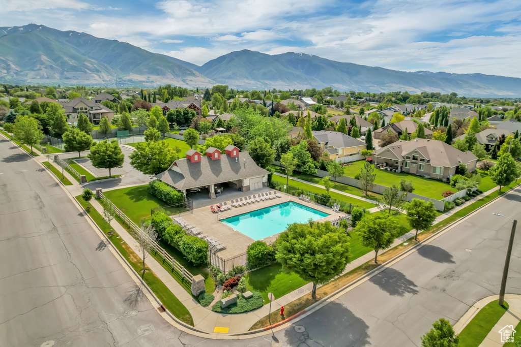 Aerial perspective of suburban area featuring a pool and a mountain backdrop