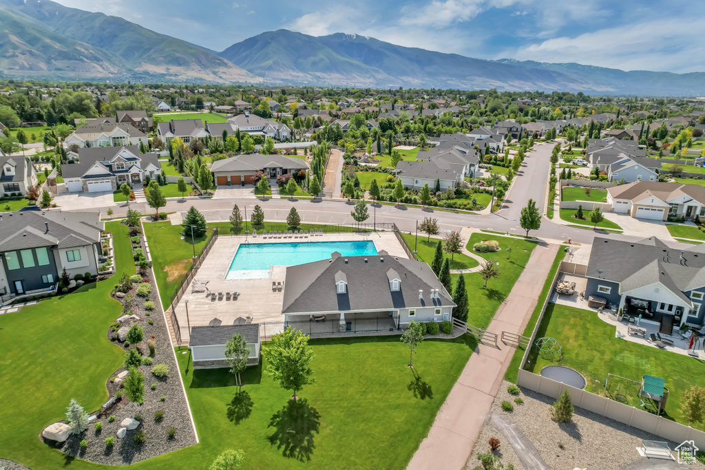 Aerial perspective of suburban area featuring a mountain backdrop and a pool area