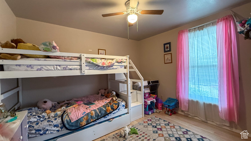 Bedroom featuring light wood-style floors, multiple windows, and a ceiling fan