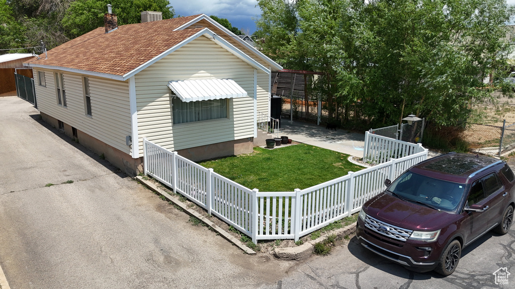 View of front facade featuring a shingled roof and a chimney