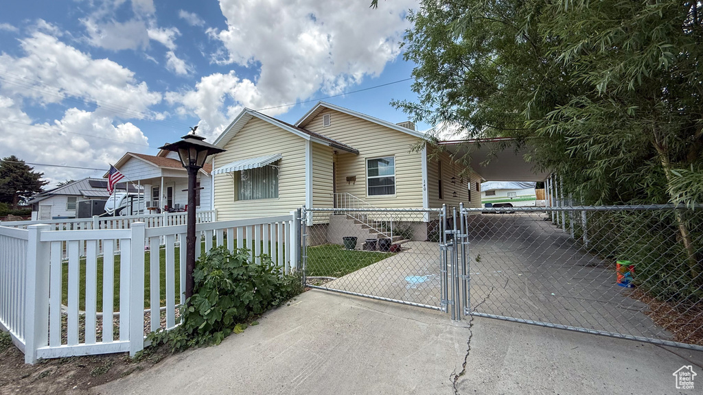 Bungalow-style house with a gate, a carport, and concrete driveway