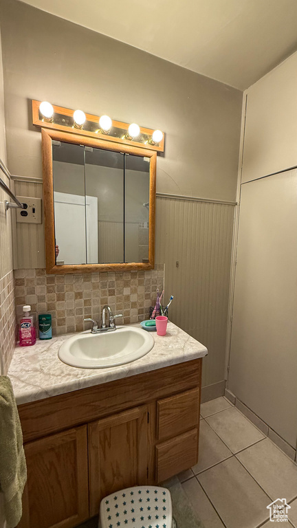 Bathroom featuring vanity, tile patterned flooring, and a wainscoted wall