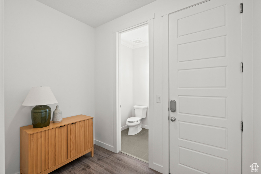 Bathroom with toilet, wood finished floors, and baseboards