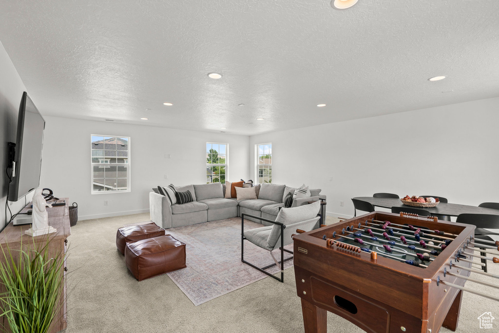 Living room with recessed lighting, carpet, a textured ceiling, and baseboards