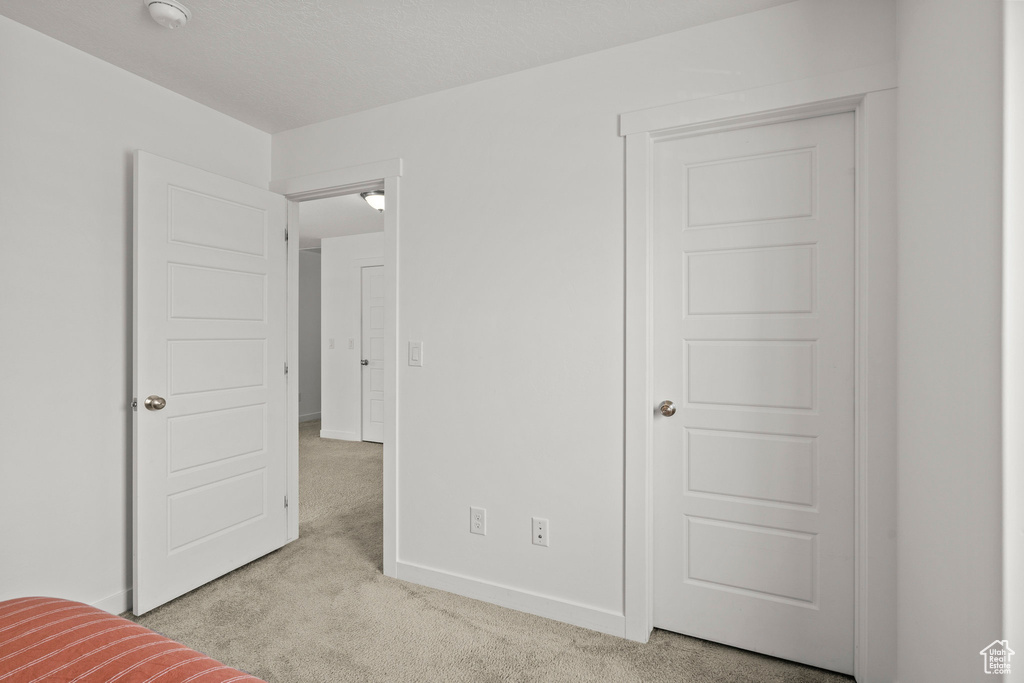 Unfurnished bedroom with carpet flooring and baseboards