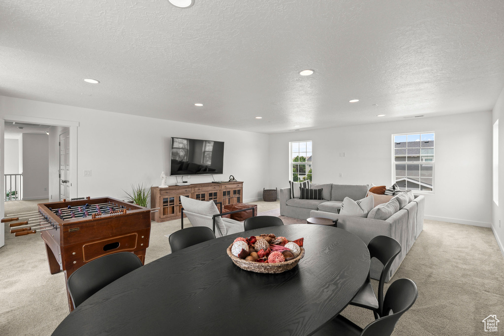 Dining area featuring light carpet, recessed lighting, a textured ceiling, and baseboards