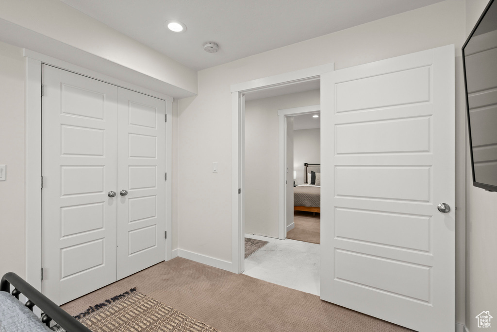 Unfurnished bedroom featuring a closet, recessed lighting, light colored carpet, and baseboards